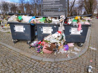 BYTOM, POLAND - 4 Nisan 2021: Bytom, Polonya 'daki bir mezarlıkta taşan mezarlık çöp bidonları.