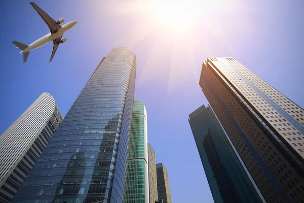 Look up at aircraft is flying modern urban office buildings — Stock Photo, Image