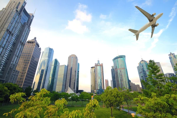 Aircraft flying over the modern city buildings — Stock Photo, Image