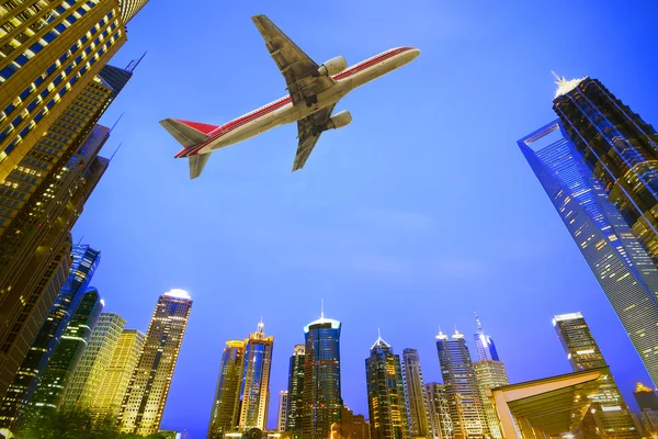 현대 도시 건물을 통해 비행 하는 항공기 — 스톡 사진