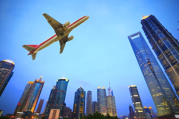 Repülőgép repül át a város modern épületek — Stock Fotó