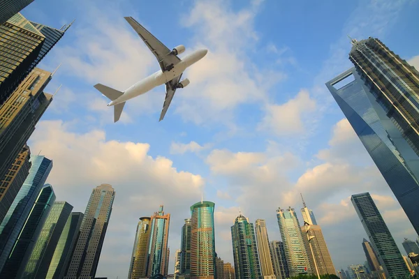 Repülőgép repül át a város modern épületek — Stock Fotó