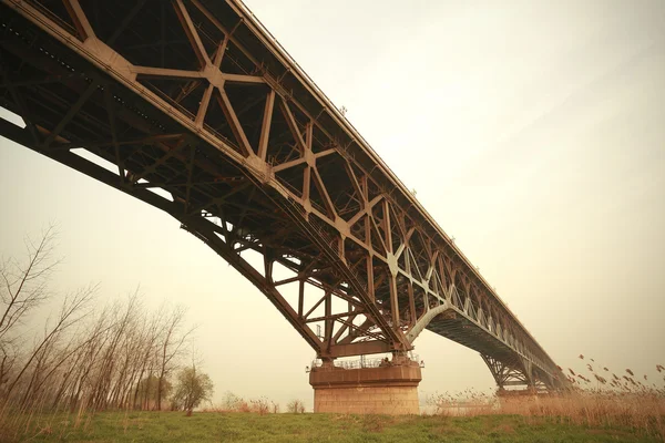 Blue steel structure bridge across the water — Stock Photo, Image