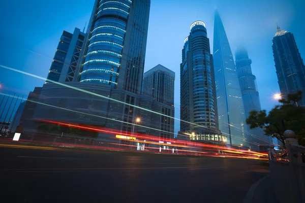 As trilhas de luz do carro da estrada de edifícios urbanos modernos — Fotografia de Stock