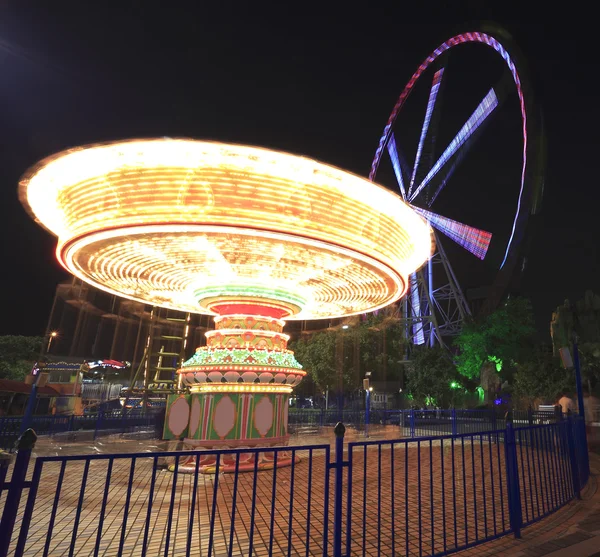 Vidámpark éjjel - óriáskerék és a körhinta — Stock Fotó