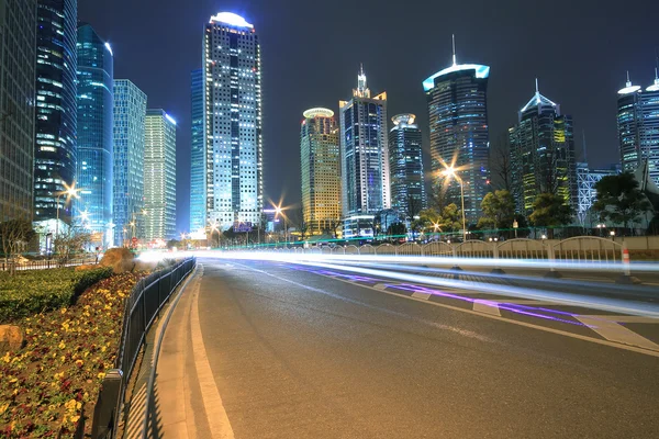 Modern office building background of car night with light trails — Stock Photo, Image