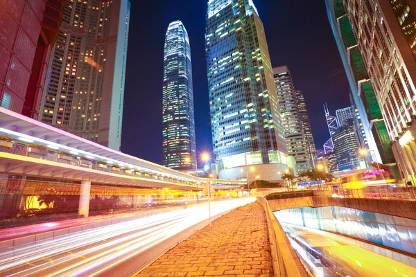 Túneis rodoviários trilhas de luz em edifícios modernos da cidade fundos i — Fotografia de Stock