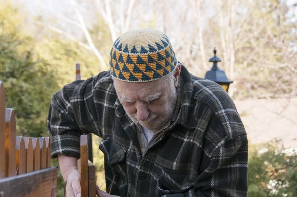 Viejo reparando una puerta — Foto de Stock