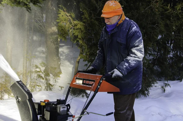 Senior man behind a snowblower — Stock Photo, Image