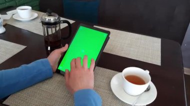 Yeşil ekranlı - kapalı tablet pc işaretli parça bir kadın eli tarafından kullanılır. Kapalı alanda gün ışığında kaydırma, kaydırma, hafifçe vurma ve okuma eylemleri