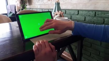 Yeşil ekranlı - kapalı tablet pc işaretli parça bir kadın eli tarafından kullanılır. Kapalı alanda gün ışığında kaydırma, kaydırma, hafifçe vurma ve okuma eylemleri