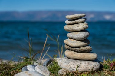 Çakıl taşı piramidi. Denizin arka planında Rock Zen. Uyum ve denge kavramı.