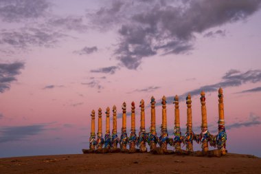 Rusya 'nın Baykal Gölü, Olkhon Adası' ndaki Khuzhir köyünde Burkhan Burnu 'ndaki kutsal buryat bölgesindeki ahşap sütunlarda renkli bant.