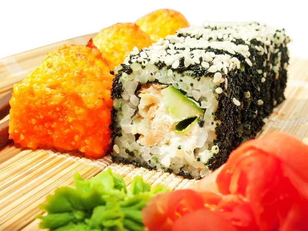 Rolls with black roe and sesame and baking sushi on bamboo mat — Stock Photo, Image