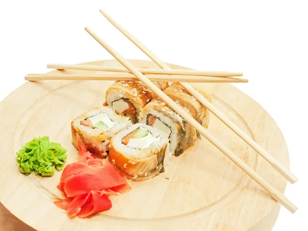 Rollos de sushi con tortilla y anguila y palillos en el escritorio sobre wh —  Fotos de Stock