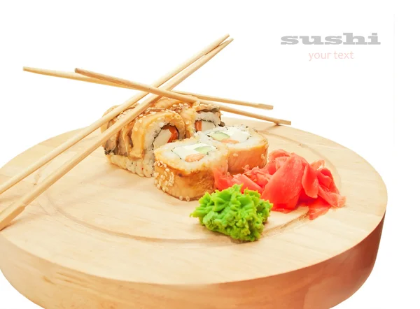 Sushi rolls with omelette and eel and chopsticks on desk over wh — Stock Photo, Image