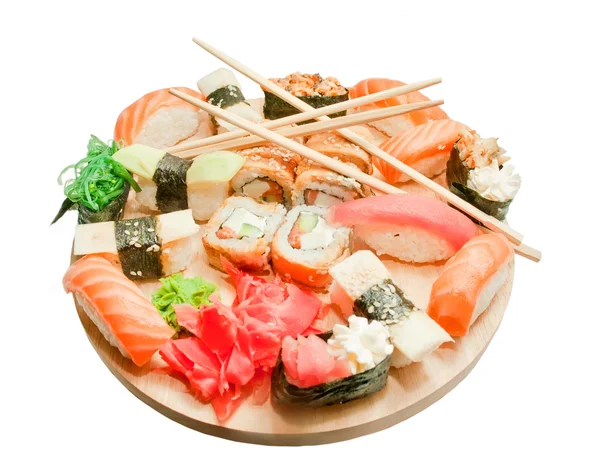 Набор суши и палочки для еды на деревянном столе, изолированные на белом — стоковое фото