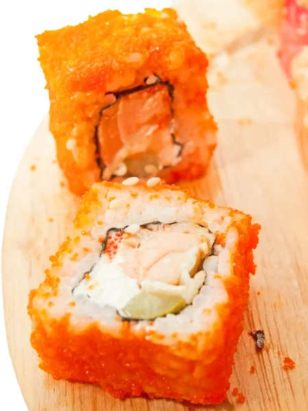 Zwei Sushi-Rollen mit Lachs und Masago auf dem Schreibtisch über weiß — Stockfoto