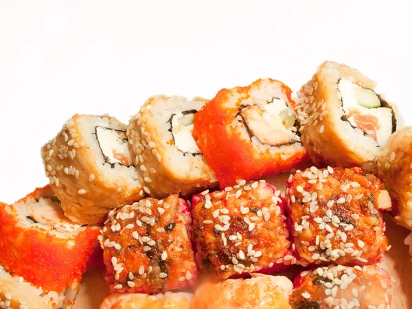 Sushi rolls in range on the desk isolated on white — Stock Photo, Image