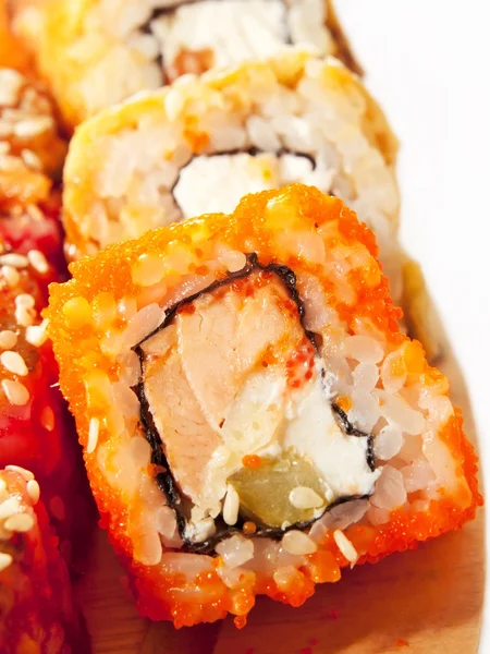 Rotoli di sushi in gamma sul primo piano scrivania isolato su bianco — Foto Stock