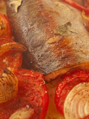 Fırında alabalık, domates ve Akdeniz tarifi için soğan.