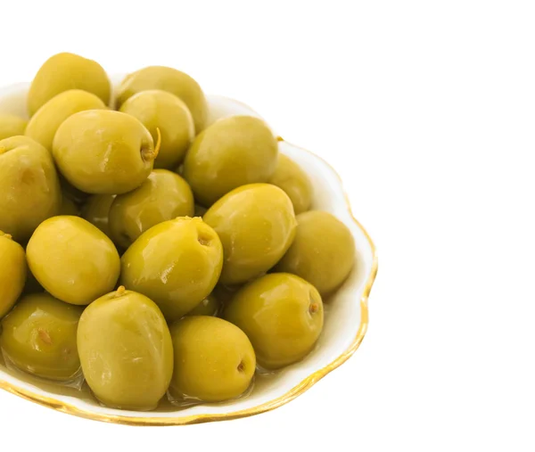 Зеленая соль оливки в белом блюде с листьями изолированы на белом — стоковое фото