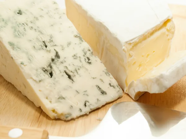 Brie en dor blauwe kaas op houten bureau met mes — Stockfoto