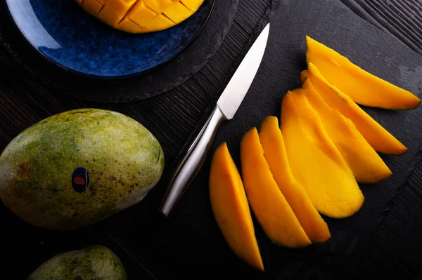 Dojrzałe Smaczne Sanki Egipskie Mango Całe Mango Serwowane Czarnym Naczyniu — Zdjęcie stockowe