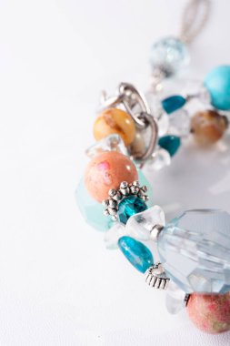 Beyaz arka planda yarı değerli taşlar olan mücevher bilezik. en üstteki görünüm