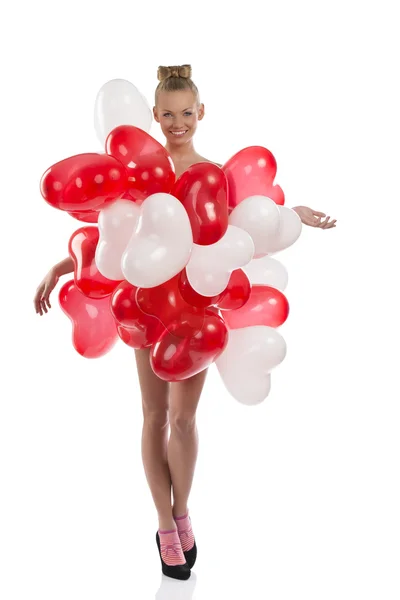 Ξανθό κορίτσι με πολλά μπαλόνια στο σώμα της φαίνεται στο φακό — Φωτογραφία Αρχείου
