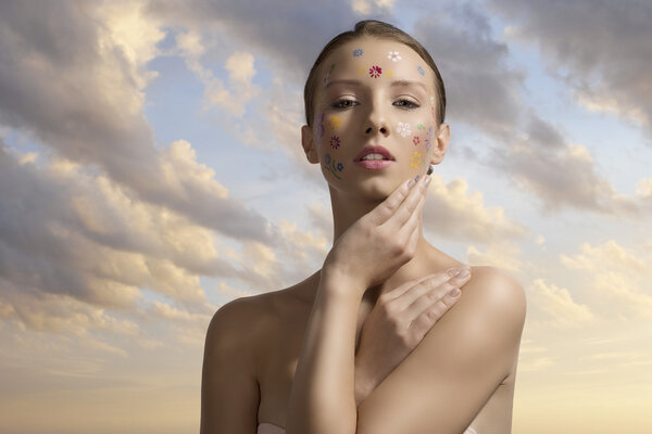 pretty girl with floral make-up with hand ner the face