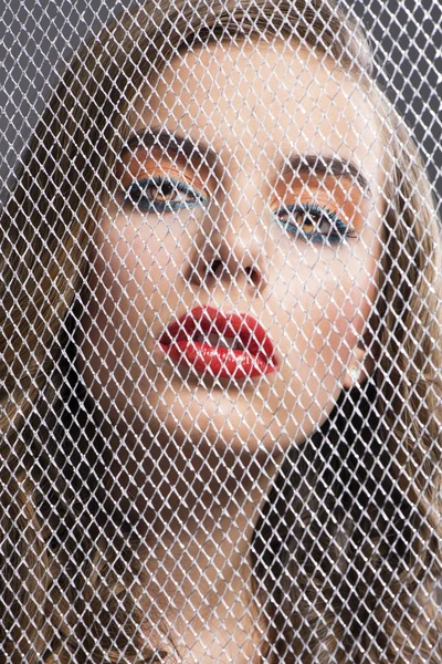 Portrait of girl behind net she is in front of the camera — Stock Photo, Image