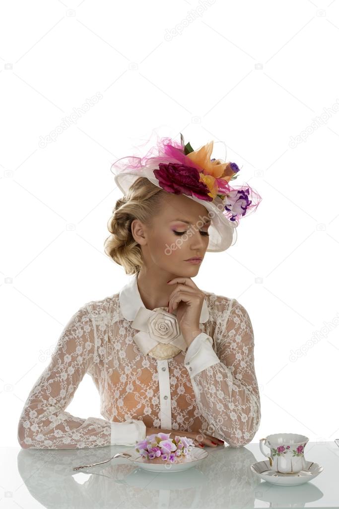 elegant girl with cake and cup of tea and closed eyes