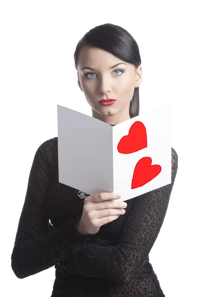 Pretty brunette with valentine postcard looks in to the lens Royalty Free Stock Photos