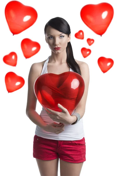 Sexy brunette with heart shaped balloon in front of the camera — Stock Photo, Image