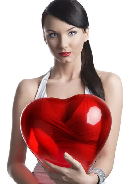 Sexy brunette with heart shaped balloon looks in to the lens — Stock Photo, Image
