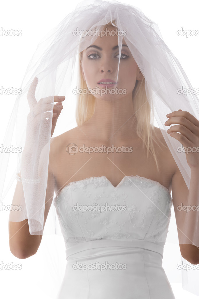 bride with veil on the face looks in to the lens