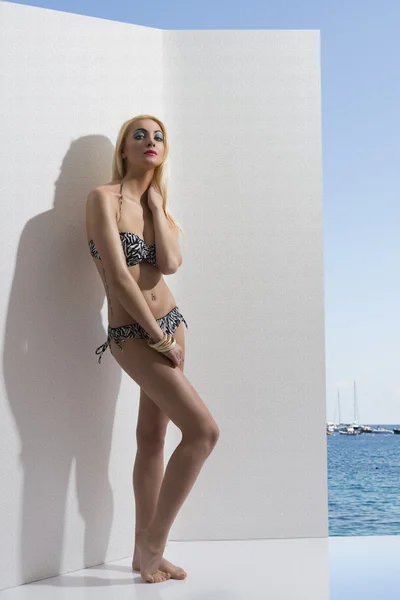 Chica rubia en bikini cerca de la pared con las manos en las caderas —  Fotos de Stock