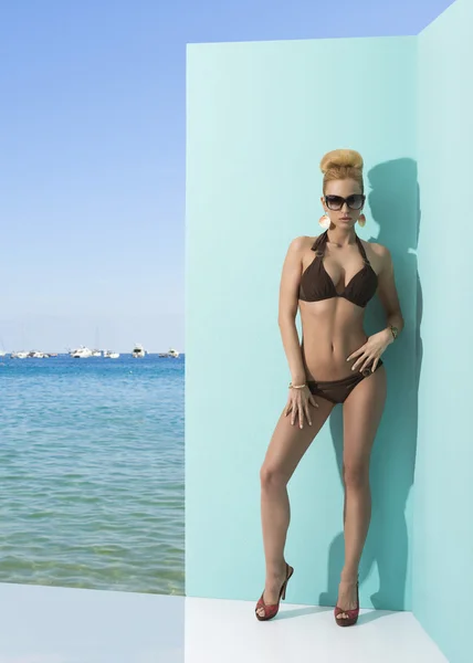 Frau im Bikini mit Sonnenbrille und Hand auf der Hüfte — Stockfoto