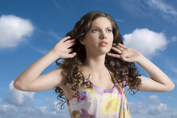 Brune ondulée avec robe colorée avec les mains dans les cheveux — Photo