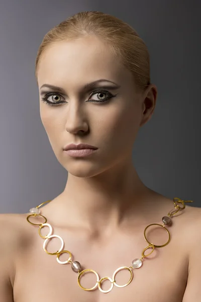 Blond meisje met ketting voor de camera — Stockfoto