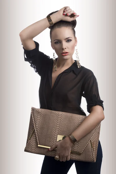 Fashion brunette with bag and hand on the head — Stock Photo, Image