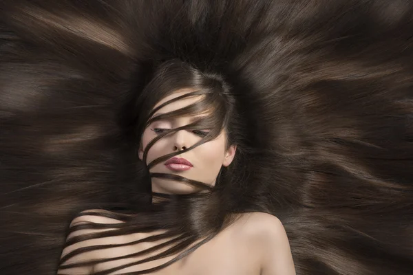 Brunette with long smooth hair looks down — Stock Photo, Image