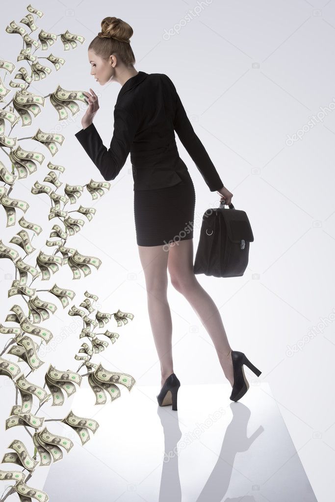 Business woman taking a dollar from money plant