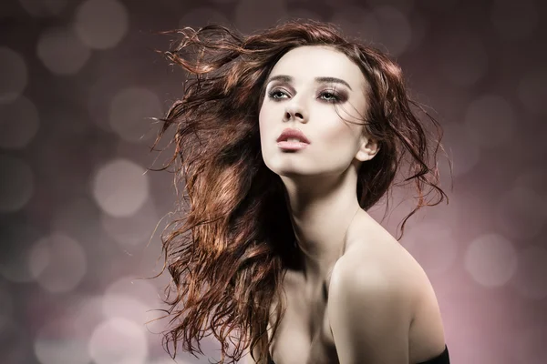 Chica de moda con el pelo volando sobre fondo de bengala —  Fotos de Stock