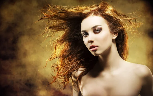 Sexy woman with flying hair on grunge background — Stock Photo, Image