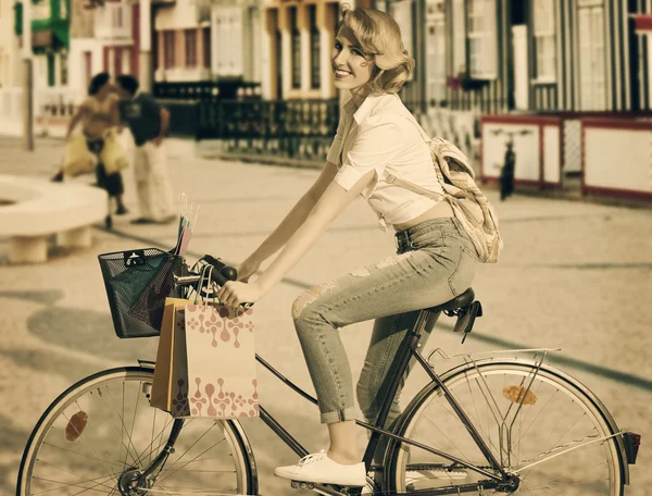 Chica rubia en bicicleta en tiempo de compras — Foto de Stock