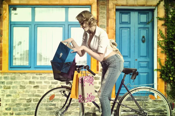 Случайная девушка с велосипедом и сумкой для покупок — стоковое фото