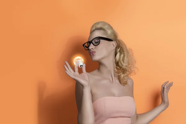 Blonde girl kissing light bulb — Stock Photo, Image