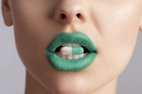 крупным планом женского рта с таблетками
